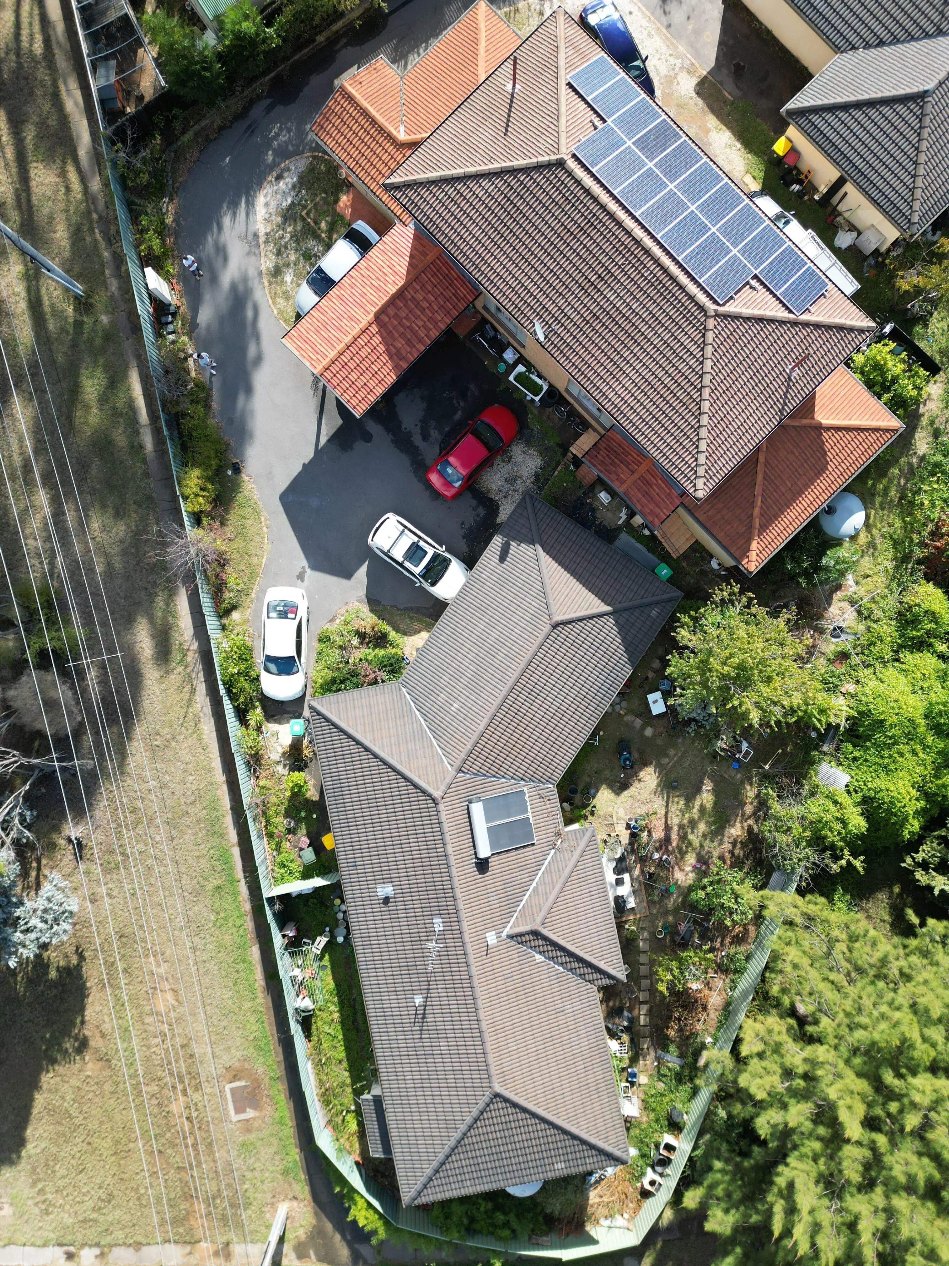 Detailed aerial view of house with grey roof and parking area