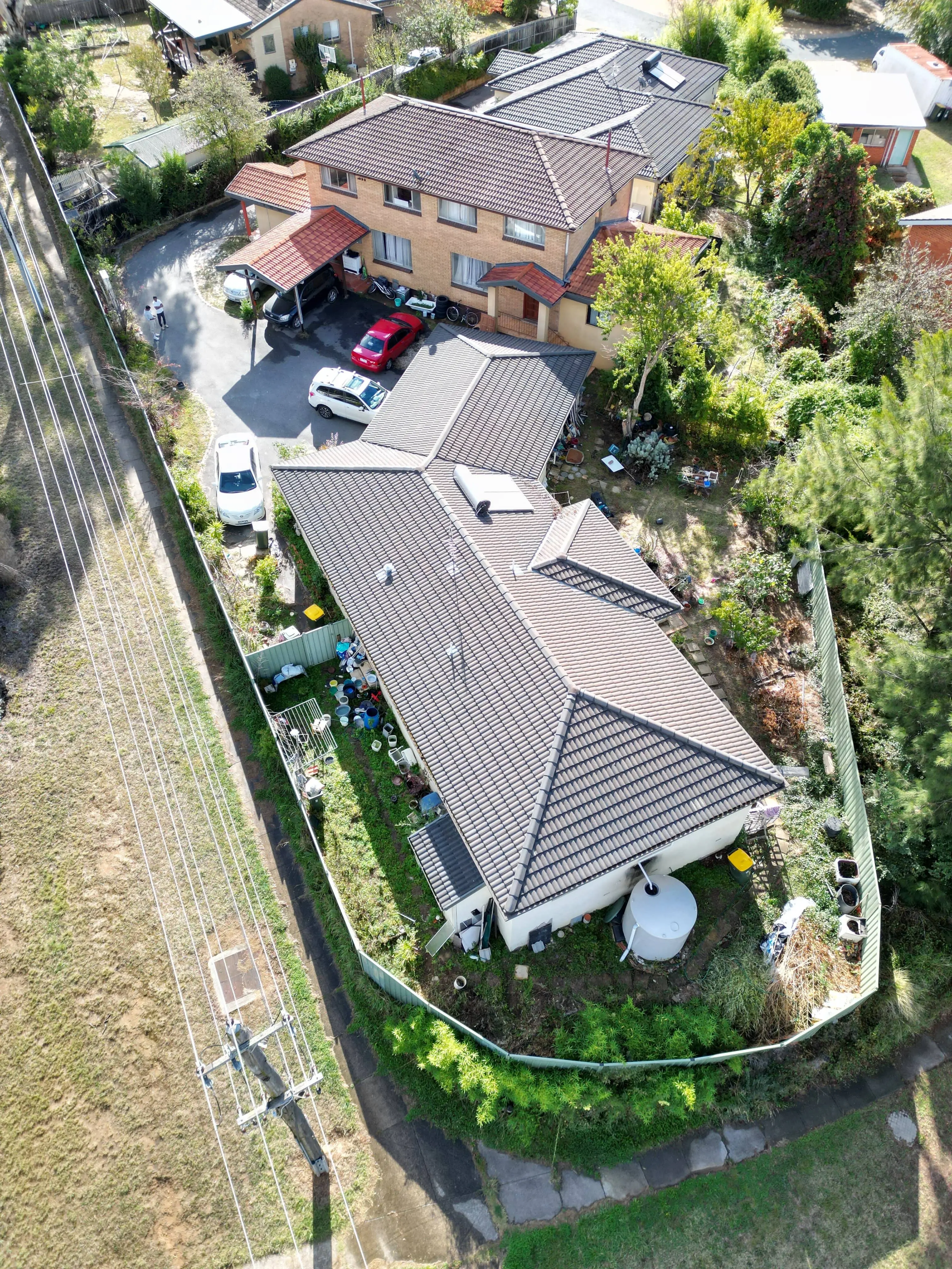 Aerial view of grey-roofed house with power line easement