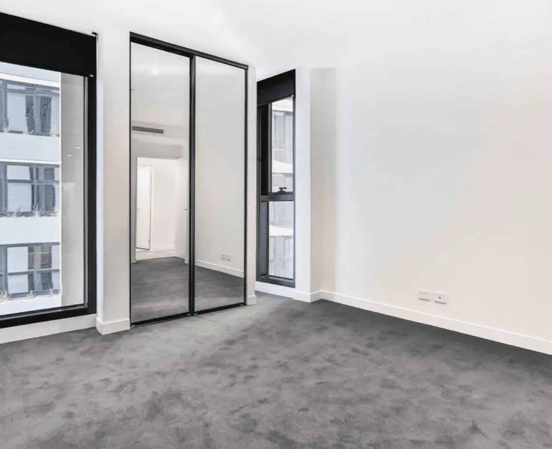 Modern bedroom with mirrored wardrobes and city views