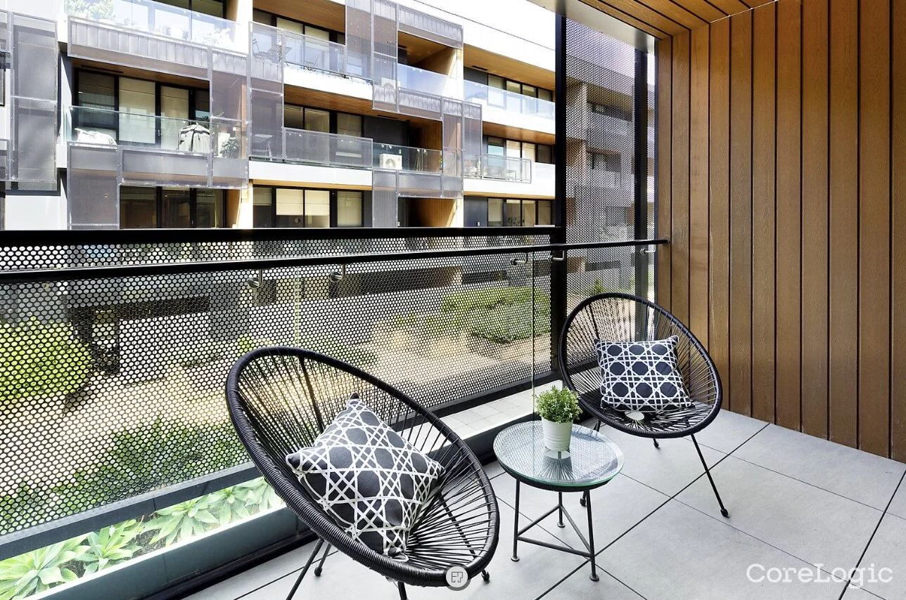 Modern apartment balcony with black chairs and timber feature wall