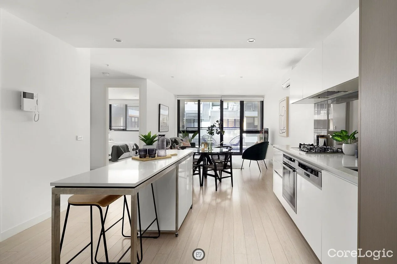 Modern open-plan apartment with white kitchen and timber floors