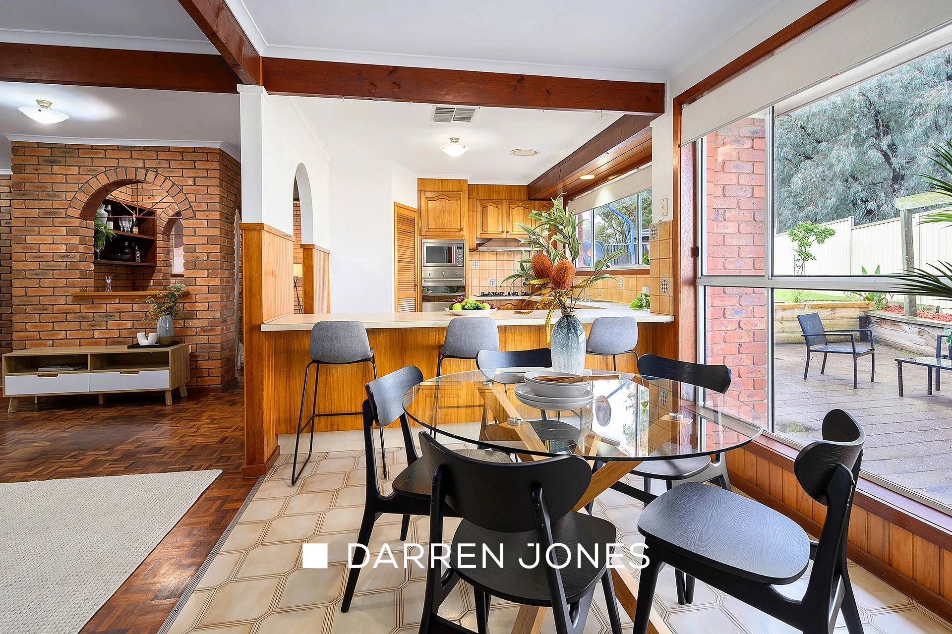 Open plan kitchen and dining area with brick arch and timber features