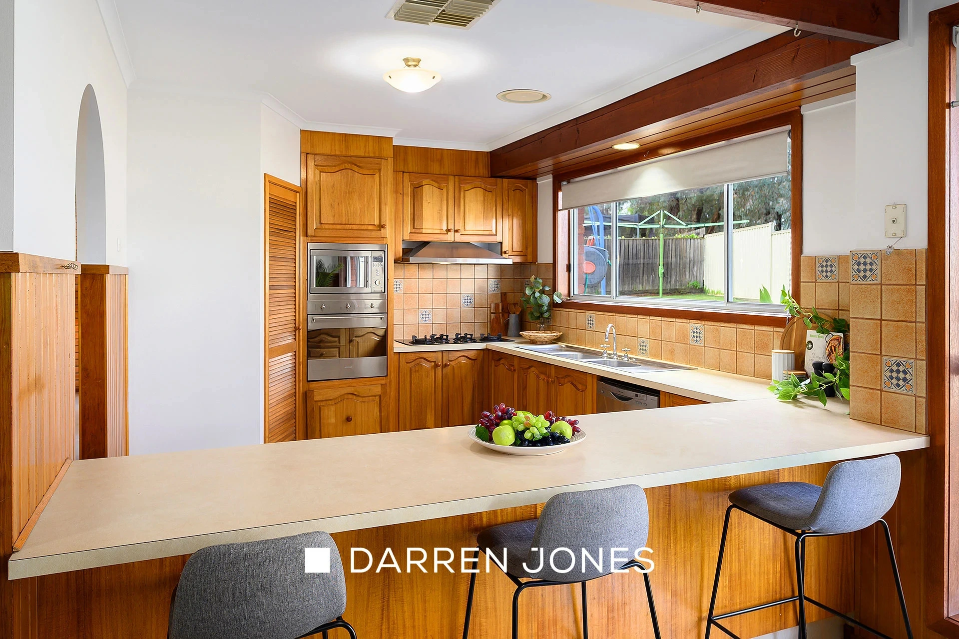 Traditional timber kitchen with beige counters and garden view
