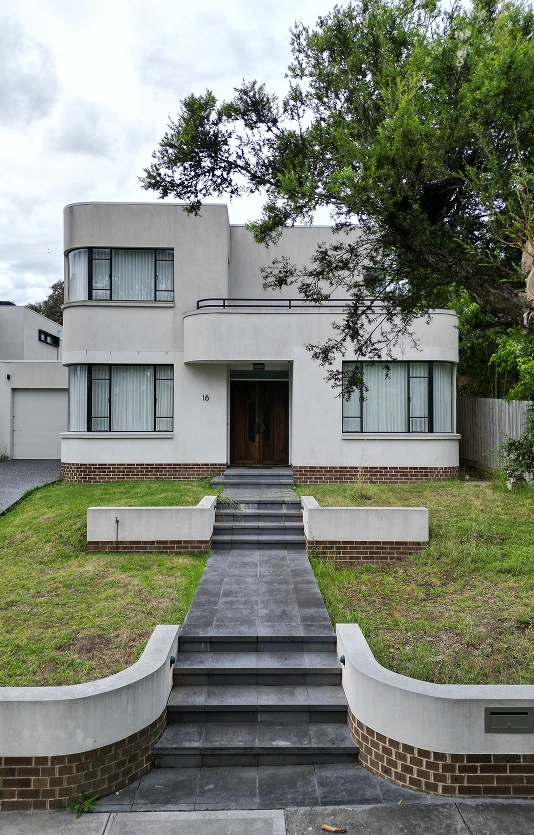 Art Deco style house in Kew East before landscaping with curved features and grey concrete pathway