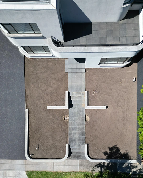 Aerial view of Kew East property during landscaping showing prepared soil and maintained concrete path
