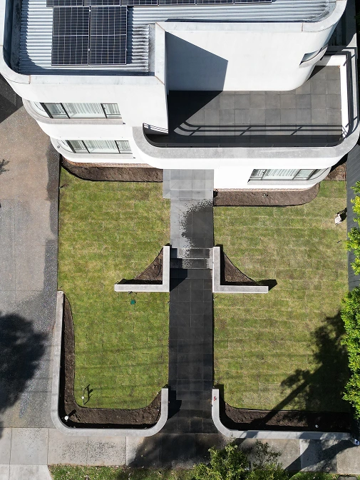 Aerial view of Kew East property showing newly laid turf, raised garden beds, and concrete pathway design