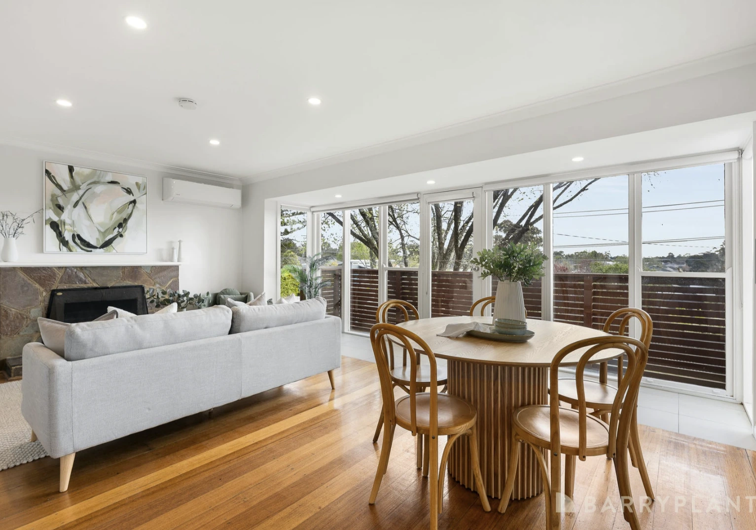 A bright and spacious renovated dining room in a Kilsyth home with timber flooring and a view to the outdoor area.