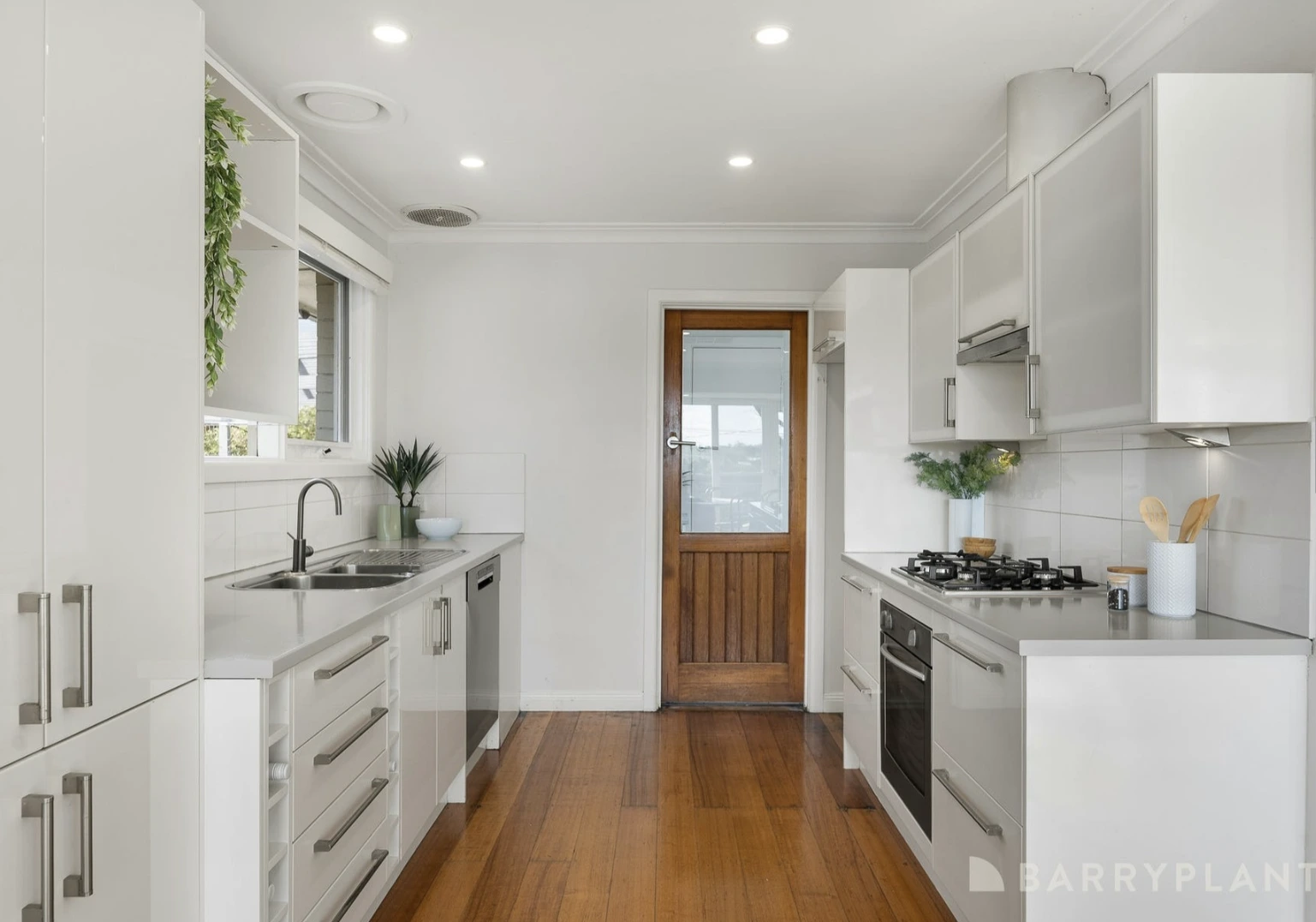 A renovated kitchen in a Kilsyth family home with new white cabinetry, a timber countertop, and a modern subway tile backsplash.