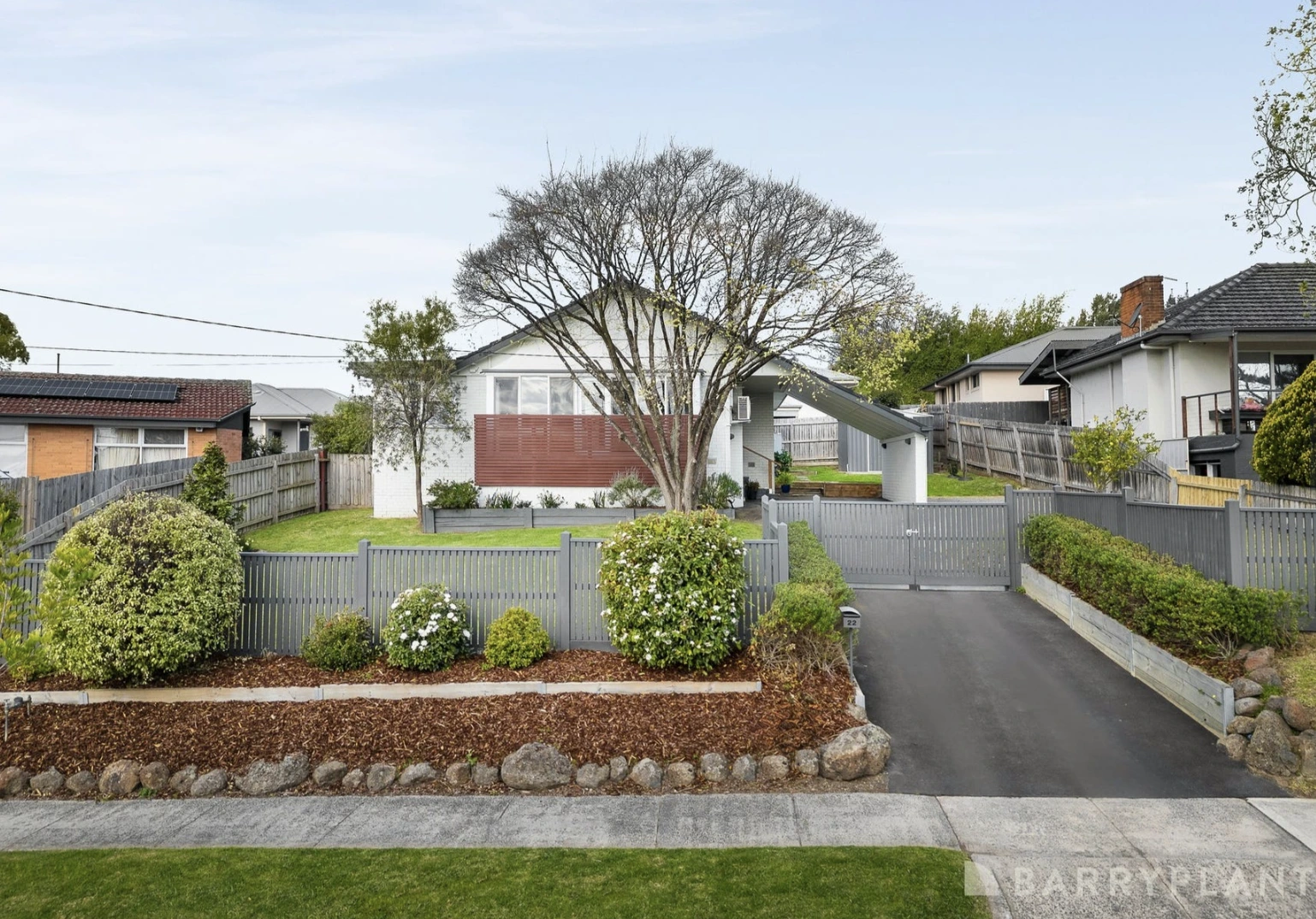 Front exterior of a renovated family home in Kilsyth, with a white facade and gray fence.