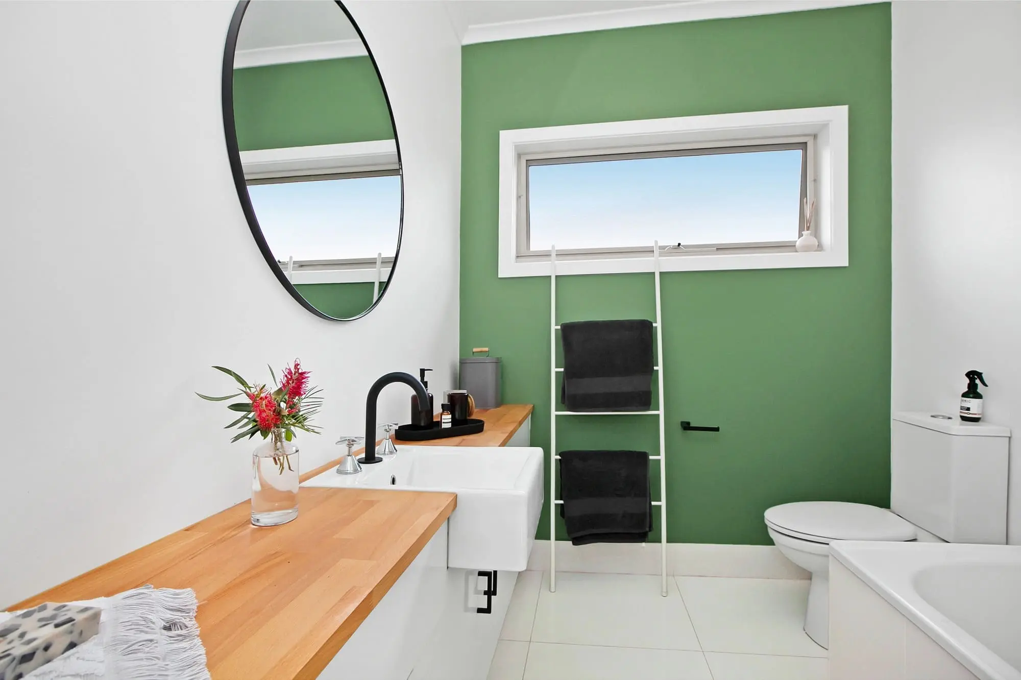 Modern bathroom with green feature wall and timber vanity