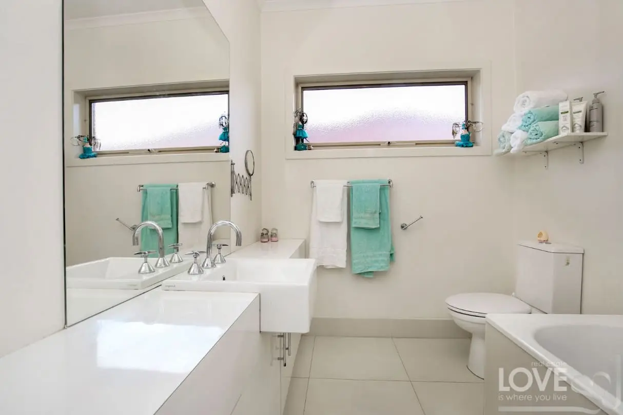 Modern white bathroom with twin basins and aqua accents