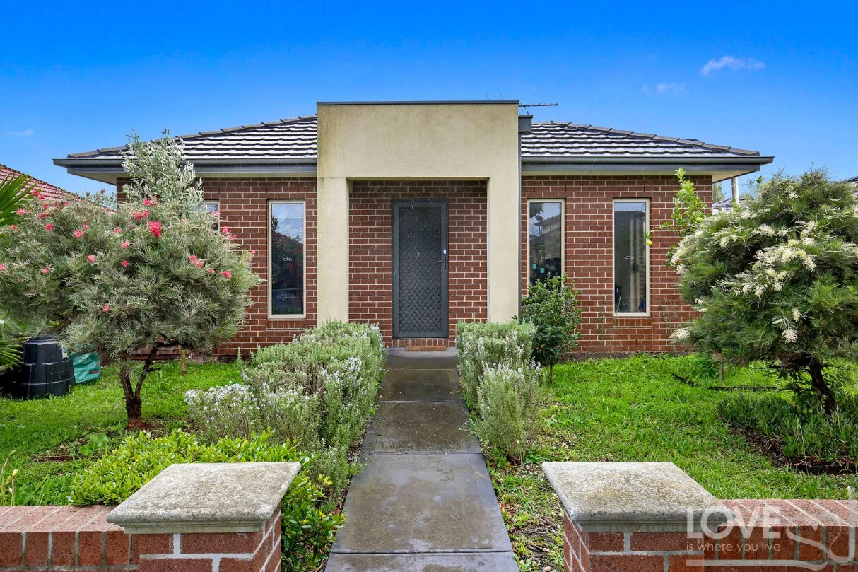 Modern red brick house with native garden and grey roof