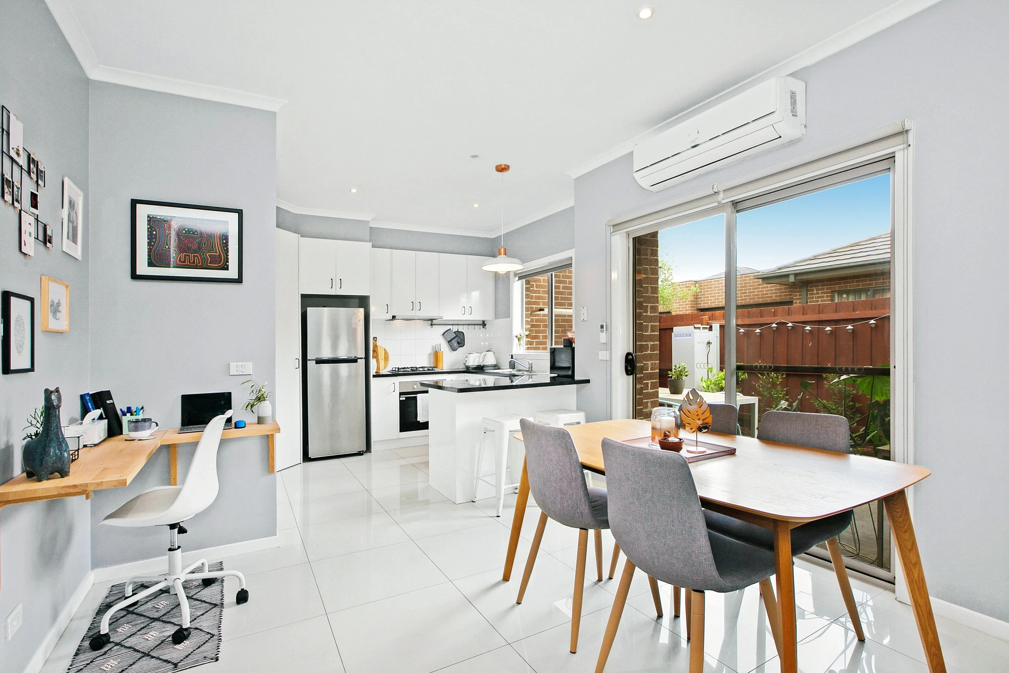 Modern white kitchen with dining area and office nook