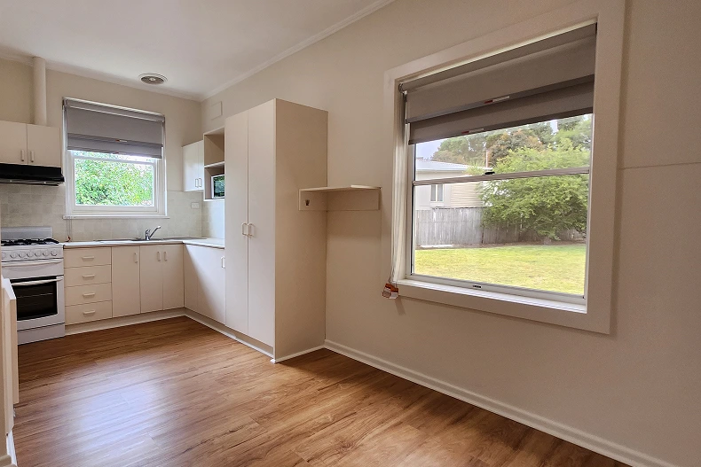 Renovated kitchen and dining space in Mt. Gambier featuring new wooden floors, modern blinds, and refreshed white cabinets