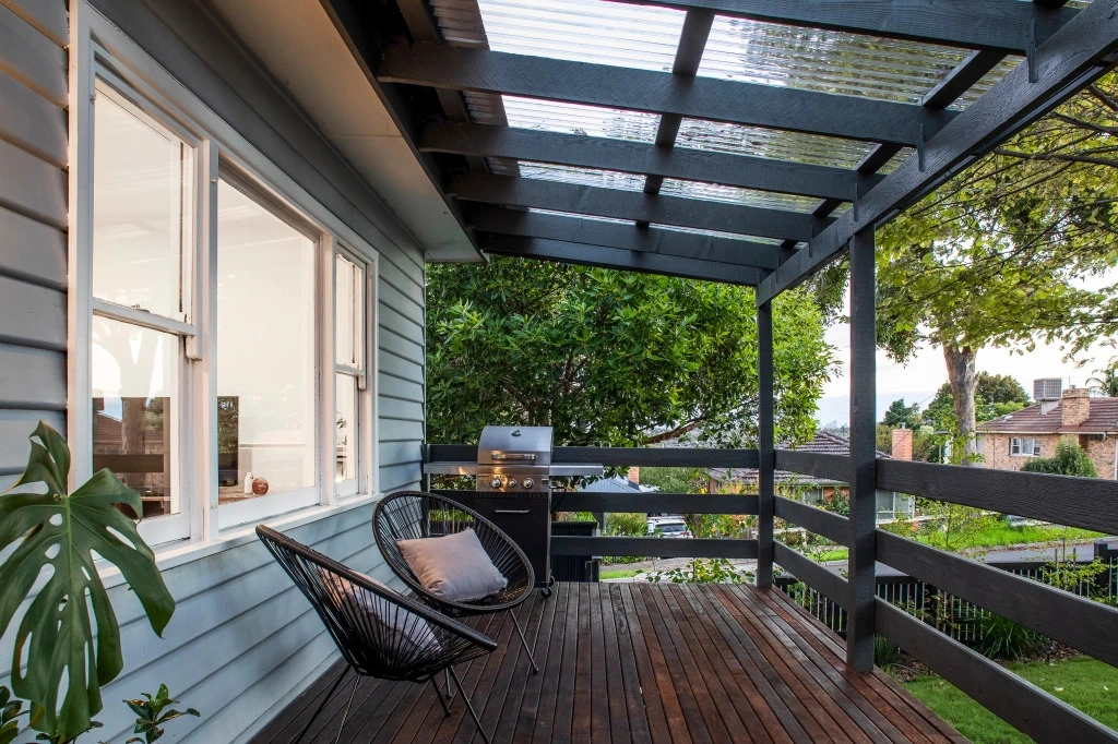 Modern renovated balcony with black pergola and outdoor furniture