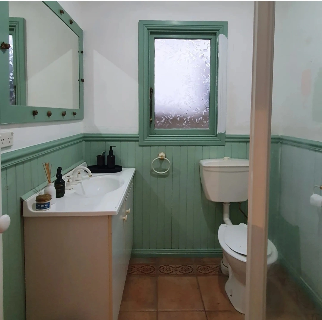 Vintage bathroom with green wainscoting and basic fixtures