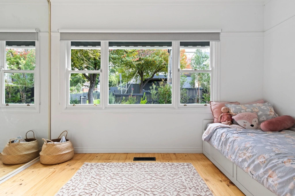 Bright modern bedroom with white walls and garden views