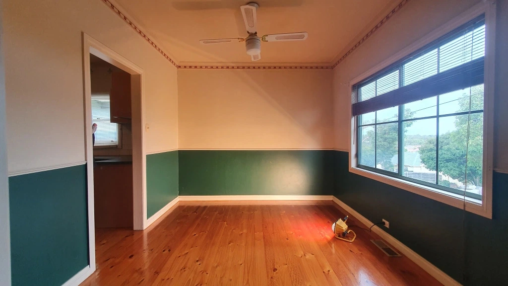 Empty dining room with two-tone walls and timber floors