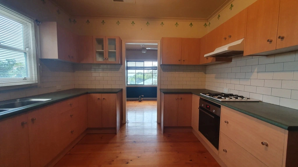 Dated U-shaped kitchen with orange cabinets before renovation