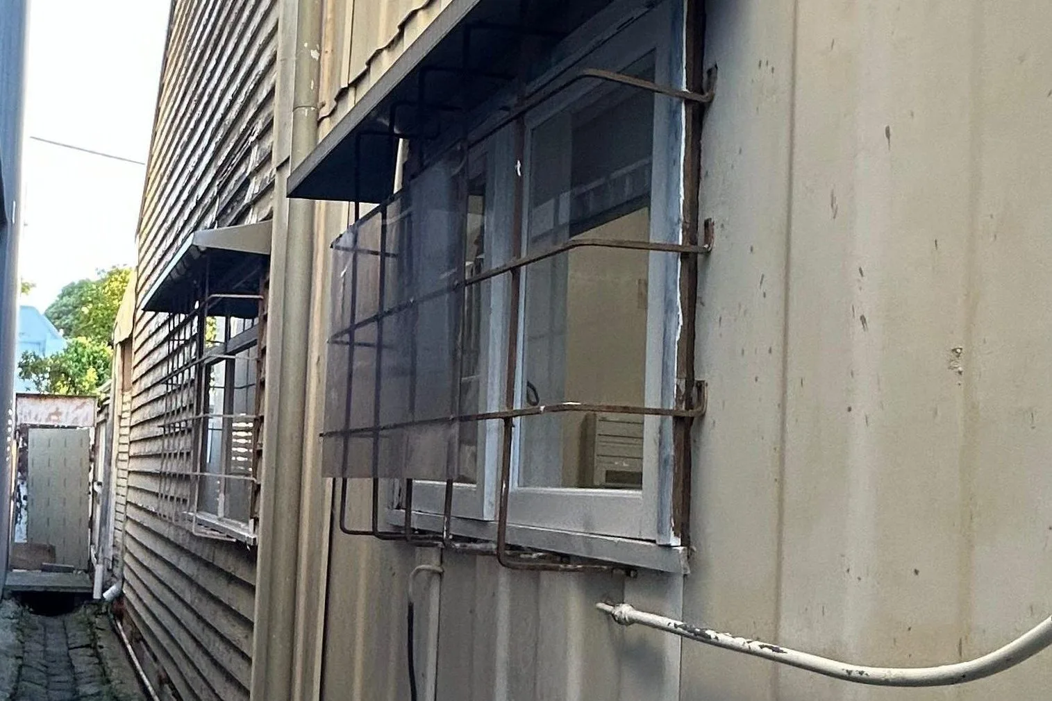 Exterior wall with old asbestos cladding and security grill